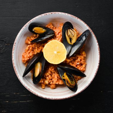 Midyeli bulgur ve tabakta domates sosu. Eski arka planda. Üst te. Metniniz için boş alan.