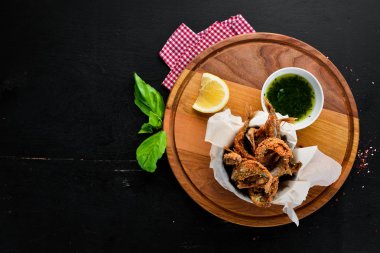 Soslu yağda pişirilen ince balık. Ahşap bir arka plan üzerinde. Üst te. Metniniz için boş alan.