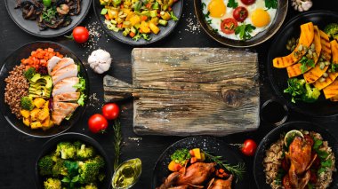 Yiyecek çeşitleri. Salata, avokado, bıldırcın, mantar, balkabağı. Siyah bir arka plan üzerinde. Üst te. Metniniz için boş alan.