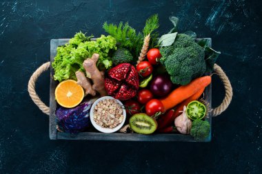 Siyah bir arka plan üzerinde ahşap bir kutu içinde taze sebze ve meyve. Organik gıda. Üst te. Ücretsiz kopyalama alanı.