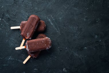 Sopanın üzerinde çikolatalı dondurma. Siyah bir arka plan üzerinde. Üst te. Ücretsiz kopyalama alanı