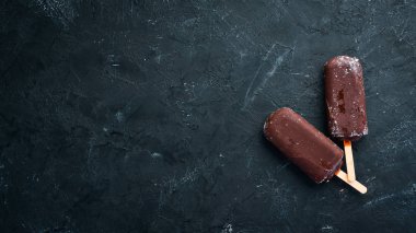 Sopanın üzerinde çikolatalı dondurma. Siyah bir arka plan üzerinde. Üst te. Ücretsiz kopyalama alanı