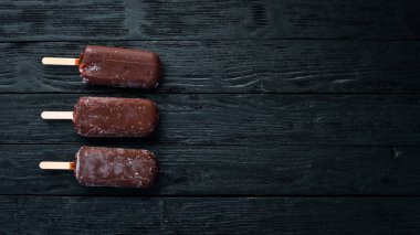 Sopanın üzerinde çikolatalı dondurma. Siyah bir arka plan üzerinde. Üst te. Ücretsiz kopyalama alanı