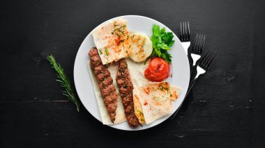 Kuzu Kebap. Pide ve baharat. Siyah bir arka plan üzerinde. Üstte görüntü.