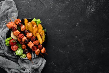 Siyah bir arka plan üzerinde patates ve sebze ile tavuk şiş kebap. Et. Üst te. Ücretsiz kopyalama alanı.