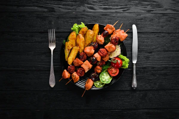 鸡烤肉串与土豆和蔬菜在黑色背景 顶部视图 免费复制空间 — 图库照片