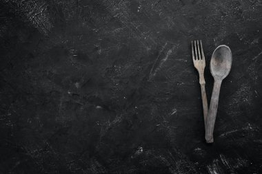 Ahşap mutfak aletleri. Siyah taştan bir arka planda. Üst Manzara. Boş kopyalama alanı.