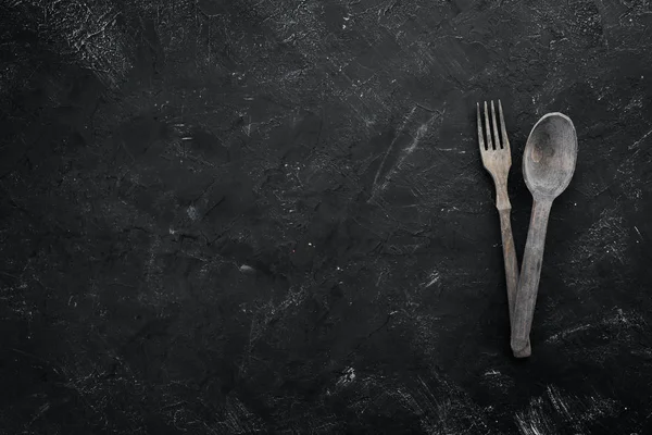 Ahşap mutfak aletleri. Siyah taştan bir arka planda. Üst Manzara. Boş kopyalama alanı.