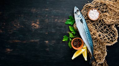 Balık. Ham Uskumru siyah ahşap bir arka plan üzerinde. Üst te. Ücretsiz kopyalama alanı.