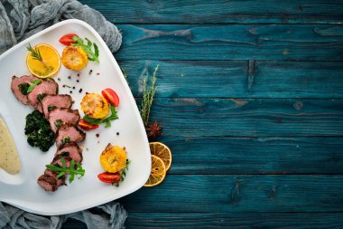 Ispanak ve mısırlı dana bifteği. Ahşap bir arka plan üzerinde. Üst te. Ücretsiz kopyalama alanı