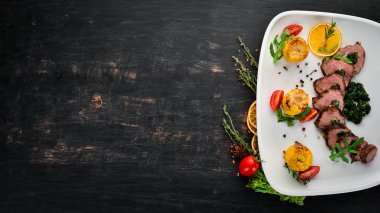 Ispanak ve mısırlı dana bifteği. Ahşap bir arka plan üzerinde. Üst te. Ücretsiz kopyalama alanı