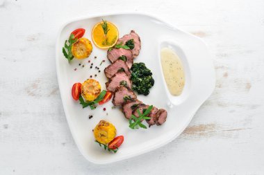 Ispanak ve mısırlı dana bifteği. Ahşap bir arka plan üzerinde. Üst te. Ücretsiz kopyalama alanı