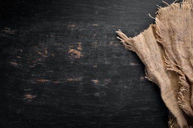 Siyah ahşap arka plan üzerinde eski keten kumaş.