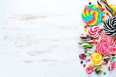 Beyaz ahşap arka plan üzerinde renkli şekerler, jöle ve marmelat. Tatlı. Üst te. ücretsiz kopyalama alanı.