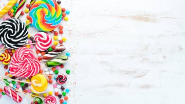 Beyaz ahşap arka plan üzerinde renkli şekerler, jöle ve marmelat. Tatlı. Üst te. ücretsiz kopyalama alanı.