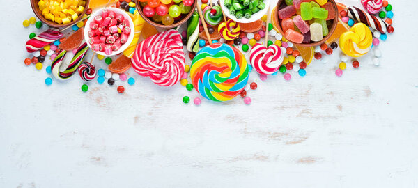 Colorful candies, jelly and marmalade on a white wooden background. Sweets. Top view. free copy space.