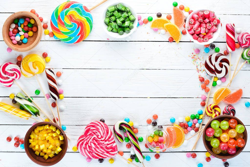 Colorful candies, jelly and marmalade on a white wooden background. Sweets. Top view. free copy space.