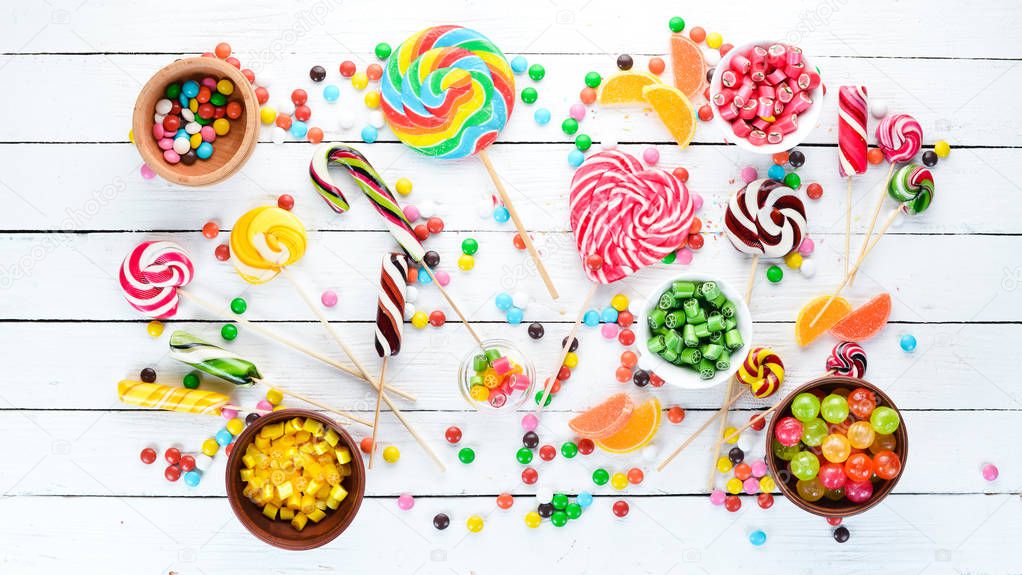 Colorful candies, jelly and marmalade on a white wooden background. Sweets. Top view. free copy space.