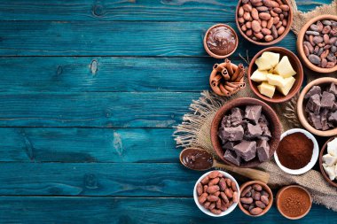 Mavi ahşap arka planda çikolata, kakao ve kakao çekirdekleri. Üst te. Ücretsiz kopyalama alanı.