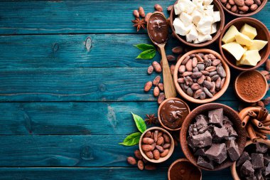 Mavi ahşap arka planda çikolata, kakao ve kakao çekirdekleri. Üst te. Ücretsiz kopyalama alanı.