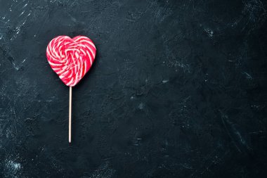 Kalp şeklinde bir sopanın üzerindeki şeker. Üst te. ücretsiz kopyalama alanı.