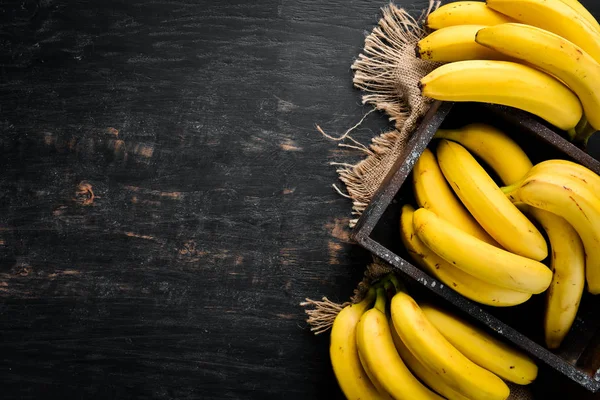 Μπανάνες Μαύρη Ξύλινη Επιφάνεια Τροπικά Φρούτα Κορυφαία Προβολή Δωρεάν Χώρος — Φωτογραφία Αρχείου