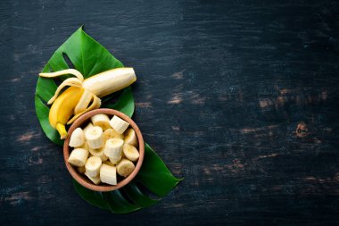 Siyah ahşap yüzeyde muz. Tropikal Meyveler. Üst te. Ücretsiz kopyalama alanı.