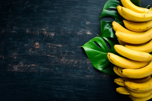 Plátanos Sobre Una Superficie Madera Negra Frutas Tropicales Vista Superior —  Fotos de Stock