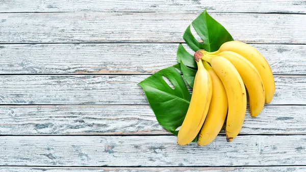 Banán Zelenými Listy Bílém Dřevěném Stole Tropické Ovoce Pohled Shora — Stock fotografie