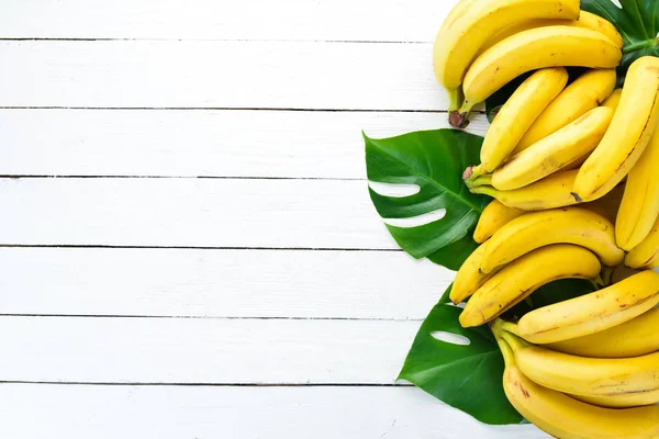 Μπανάνα Πράσινα Φύλλα Ένα Λευκό Ξύλινο Τραπέζι Τροπικά Φρούτα Κορυφαία — Φωτογραφία Αρχείου