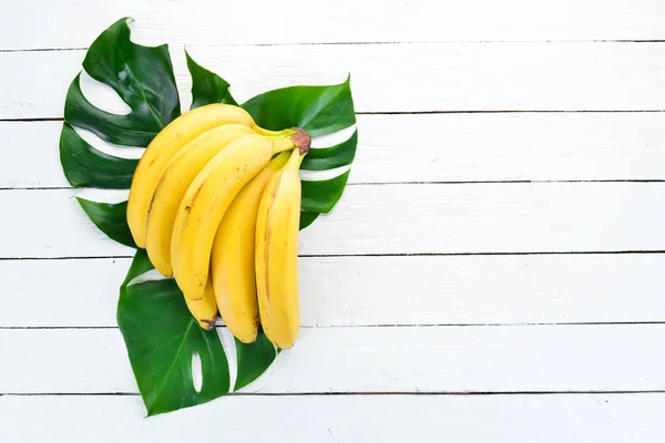 Banán Zöld Levelei Fehér Fából Készült Asztal Trópusi Gyümölcsök Felülnézet — Stock Fotó