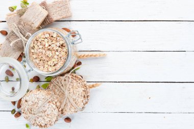 Yulaf ezmesi, müsli, keten, sağlıklı atıştırmalıklar. Beyaz ahşap bir arka plan üzerinde. Üst te. Metniniz için boş alan.