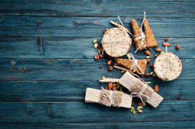 Sağlıklı atıştırmalıklar. yulaf ezmesi barlar, kruvasan, kuru üzüm, fındık. Mavi arka planda. Üst te. Metniniz için boş alan.