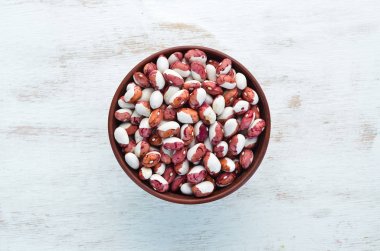 Beyaz ahşap arka plan üzerinde bir kase içinde Çiğ fasulye.