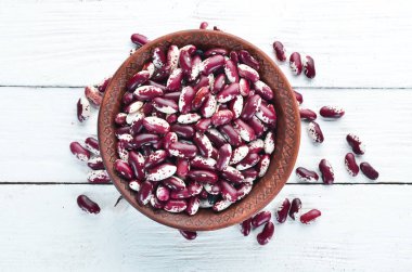 Beyaz ahşap arka plan üzerinde bir kase içinde Çiğ fasulye.