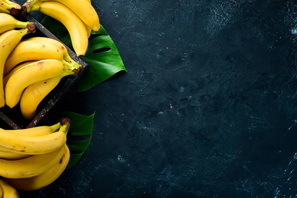 Φρέσκες Κίτρινες Μπανάνες Ένα Μαύρο Πέτρινο Τραπέζι Κορυφαία Προβολή Δωρεάν — Φωτογραφία Αρχείου