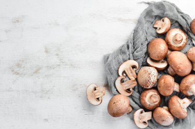 Beyaz ahşap arka plan üzerinde mantarlar. Champignons Üst görünüm. Ücretsiz kopyalama alanı.