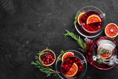 Böğürtlen ve portakal ile sıcak çay. Siyah mutfak arka planında. Üst te. Metniniz için boş alan.