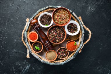 Tahta bir kutuda baharatlar. Renkli biber, deniz tuzu, karabiber, acı biber. Üstte görüntü.