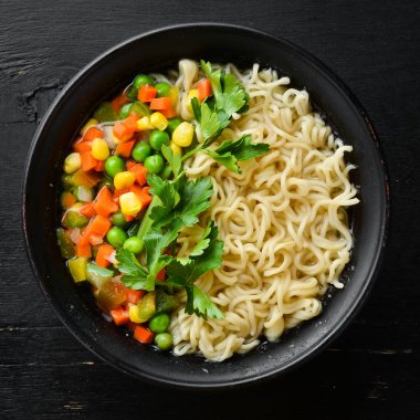 Bir kasede erişte ve sebze ile Asya çorbası, tost ekmeği ile. Diyet yemekleri. Üst te. Ücretsiz kopyalama alanı.