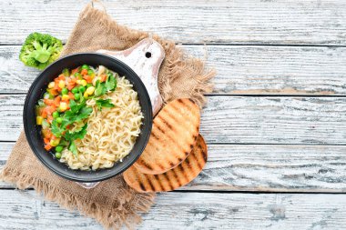 Bir kasede erişte ve sebze ile Asya çorbası, tost ekmeği ile. Diyet yemekleri. Üst te. Ücretsiz kopyalama alanı.