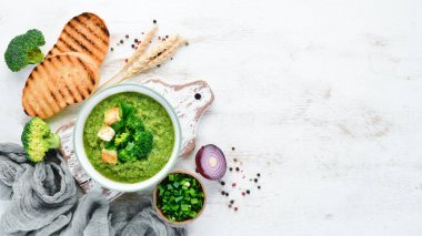 Brokoli, kızarmış ekmek ile bir kapta ıspanak krema çorbası. Yeşil çorba. Diyet yemekleri. Üstte görüntü.