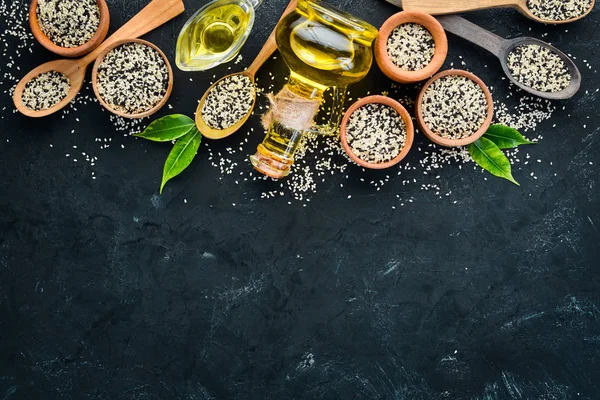 Seeds of sesame and sesame oil. On the old background. Top view. Free copy space.