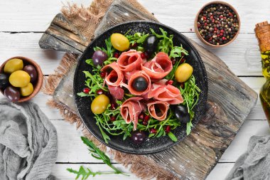 Prosciutto, zeytin ve arugula ile Salata. Soğuk atıştırmalıklar. Üst te. Metniniz için boş alan.