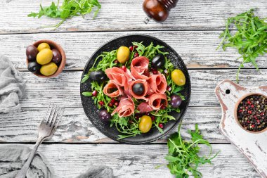 Prosciutto, zeytin ve arugula ile Salata. Soğuk atıştırmalıklar. Üst te. Metniniz için boş alan.