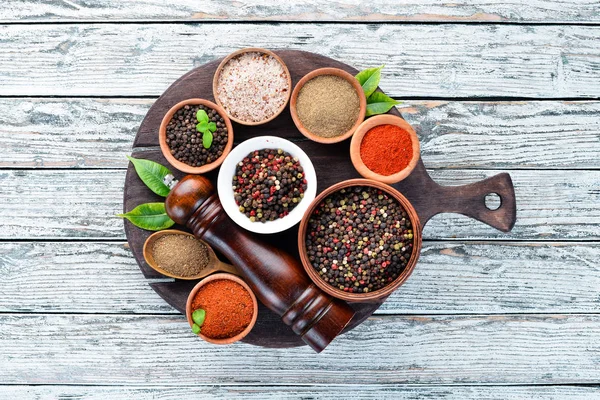 Black pepper, colored pepper, sea salt, ground pepper, dried chili pepper. Top view. On a white background. free space for your text.