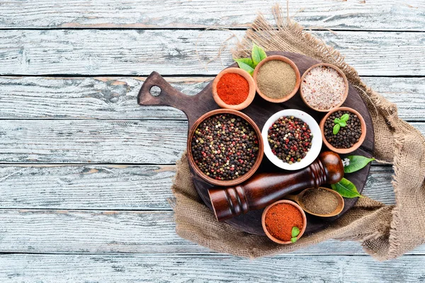 Black pepper, colored pepper, sea salt, ground pepper, dried chili pepper. Top view. On a white background. free space for your text.