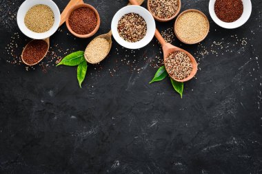 Kırmızı, beyaz ve kahverengi kinoa seti. Siyah bir arka planda. Üst Manzara. Boş kopyalama alanı.