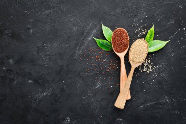 Kırmızı, beyaz ve kahverengi kinoa seti. Siyah bir arka planda. Üst Manzara. Boş kopyalama alanı.