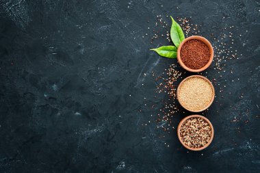 Kırmızı, beyaz ve kahverengi kinoa seti. Siyah bir arka planda. Üst Manzara. Boş kopyalama alanı.